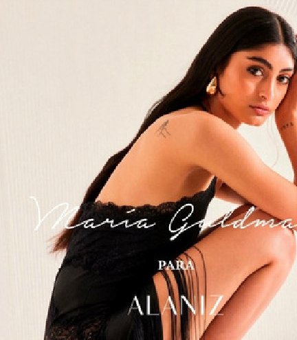 Modelo con vestido de encaje negro sentada en el suelo.