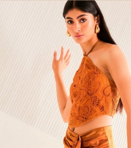 Modelo con top y pareo naranja con flecos.