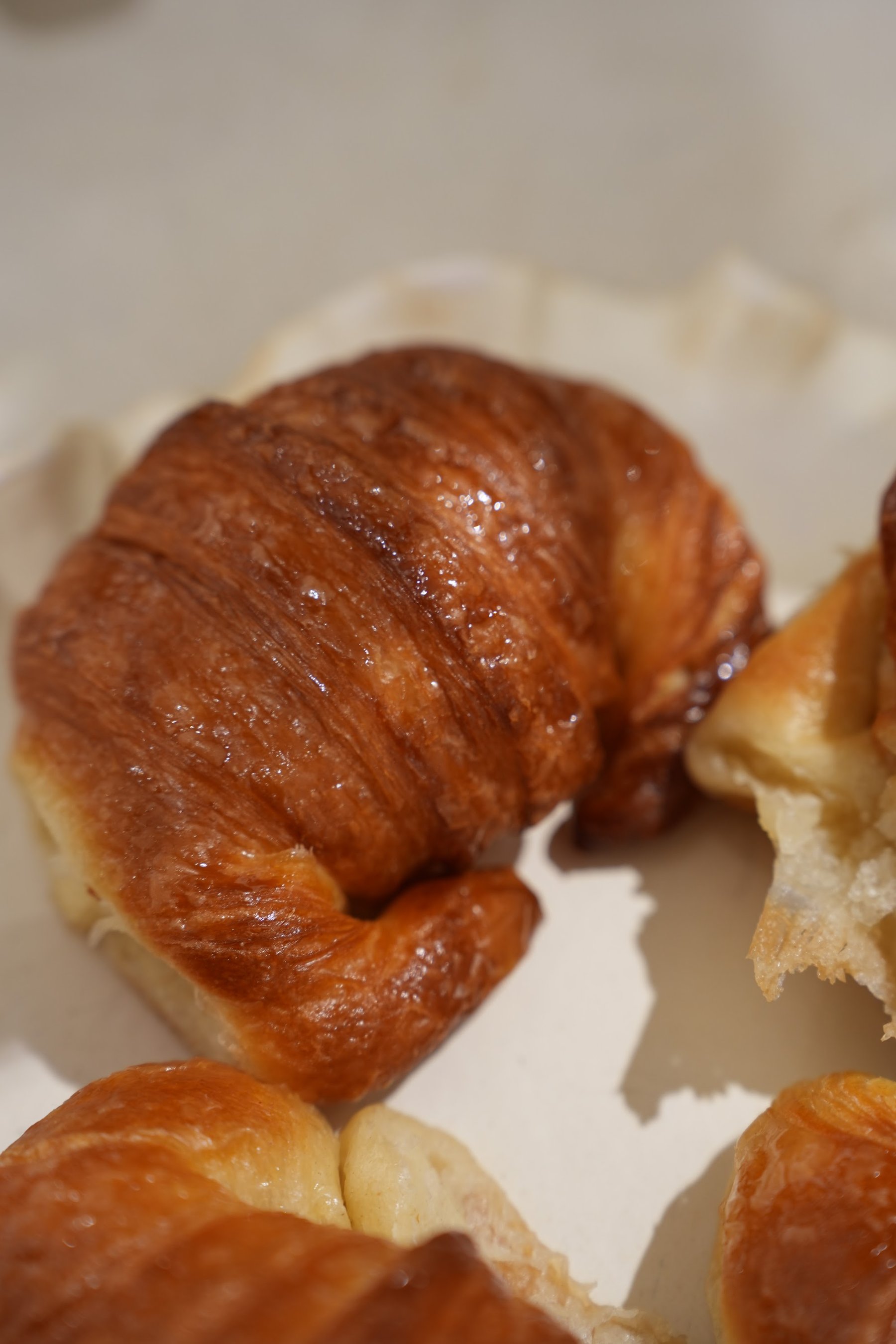 Croissants dispuestos sobre una bandeja de cerámica ondulada.