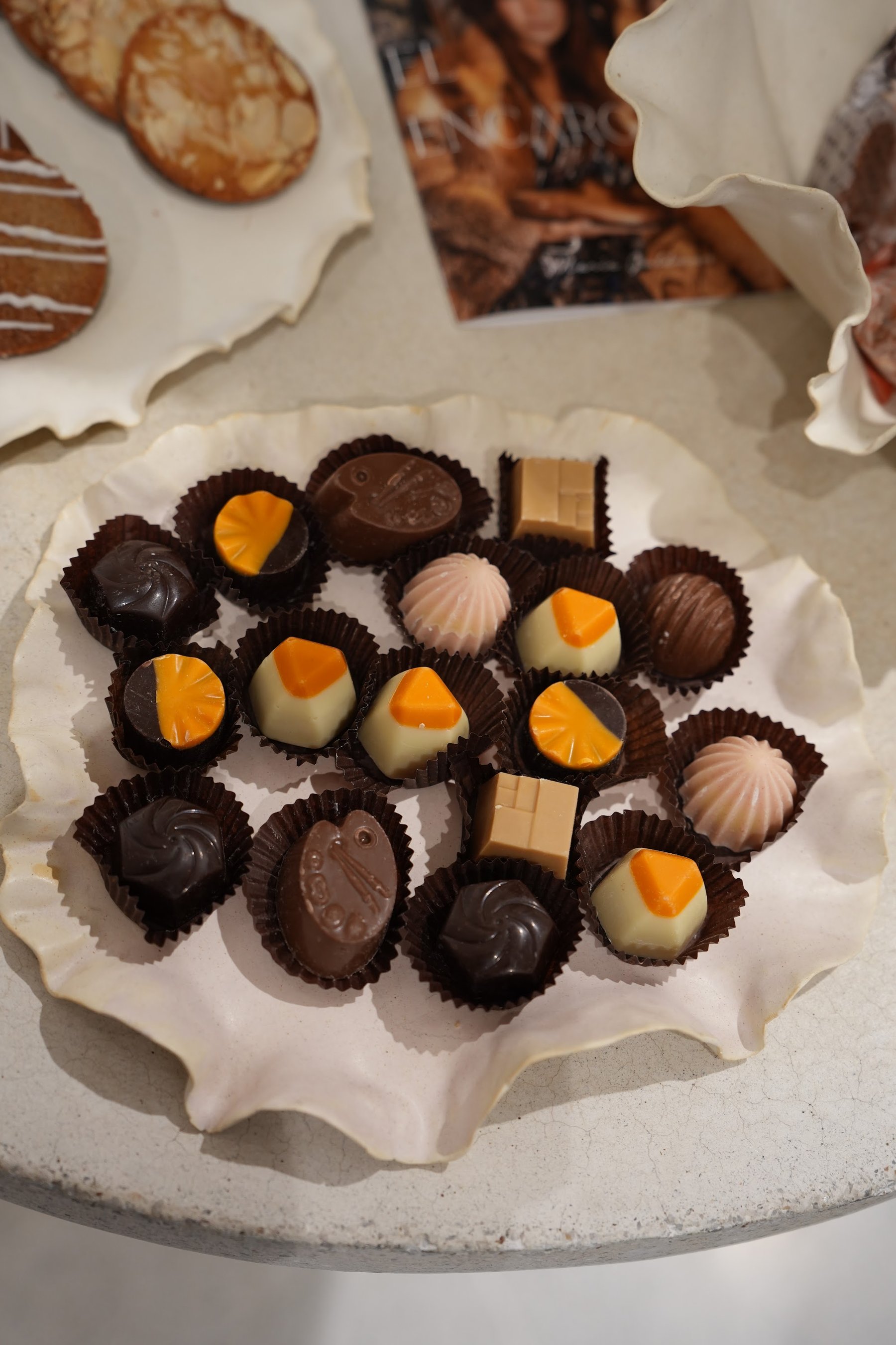 Bandejas de cerámica con bombones y galletas sobre la mesa dulce.