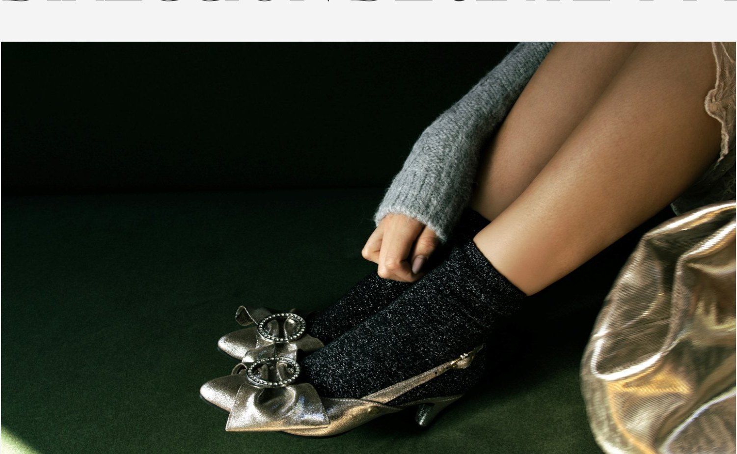 Piernas con calcetines de lana y zapatos plateados sobre fondo verde oscuro.