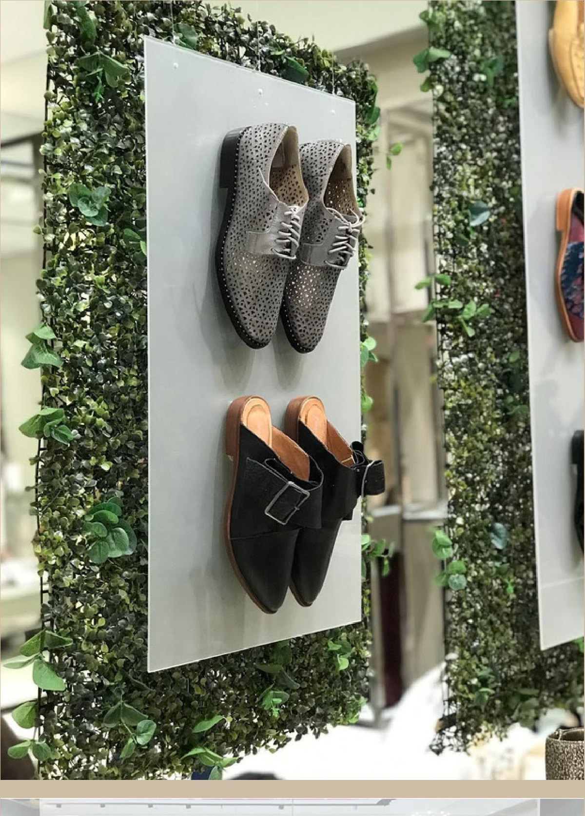 Panel de follaje con zapatos montados sobre placas blancas.