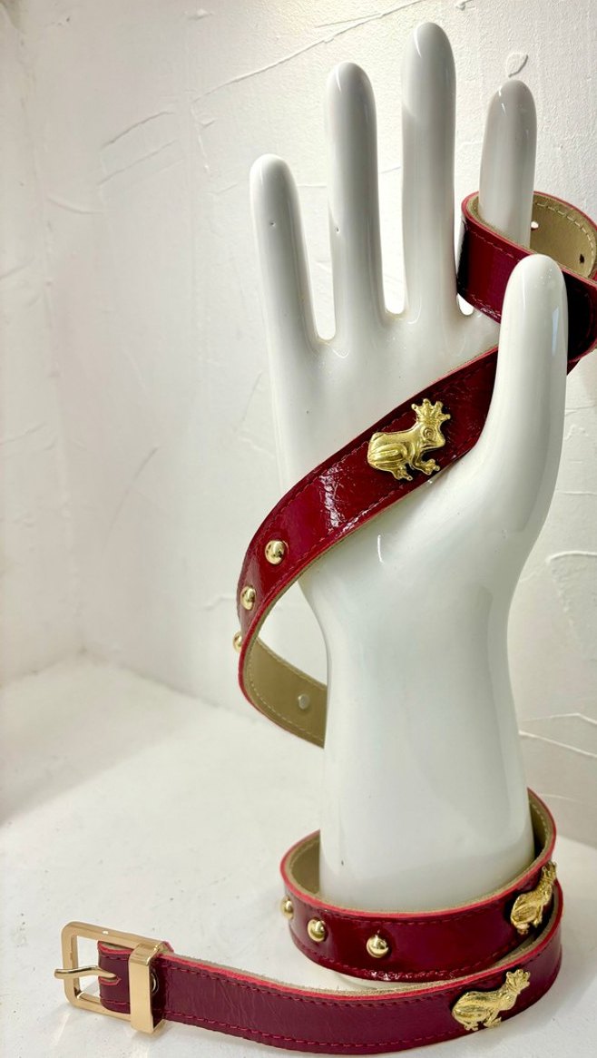Mano de exhibición en cerámica con un cinturón burdeo enrollado.