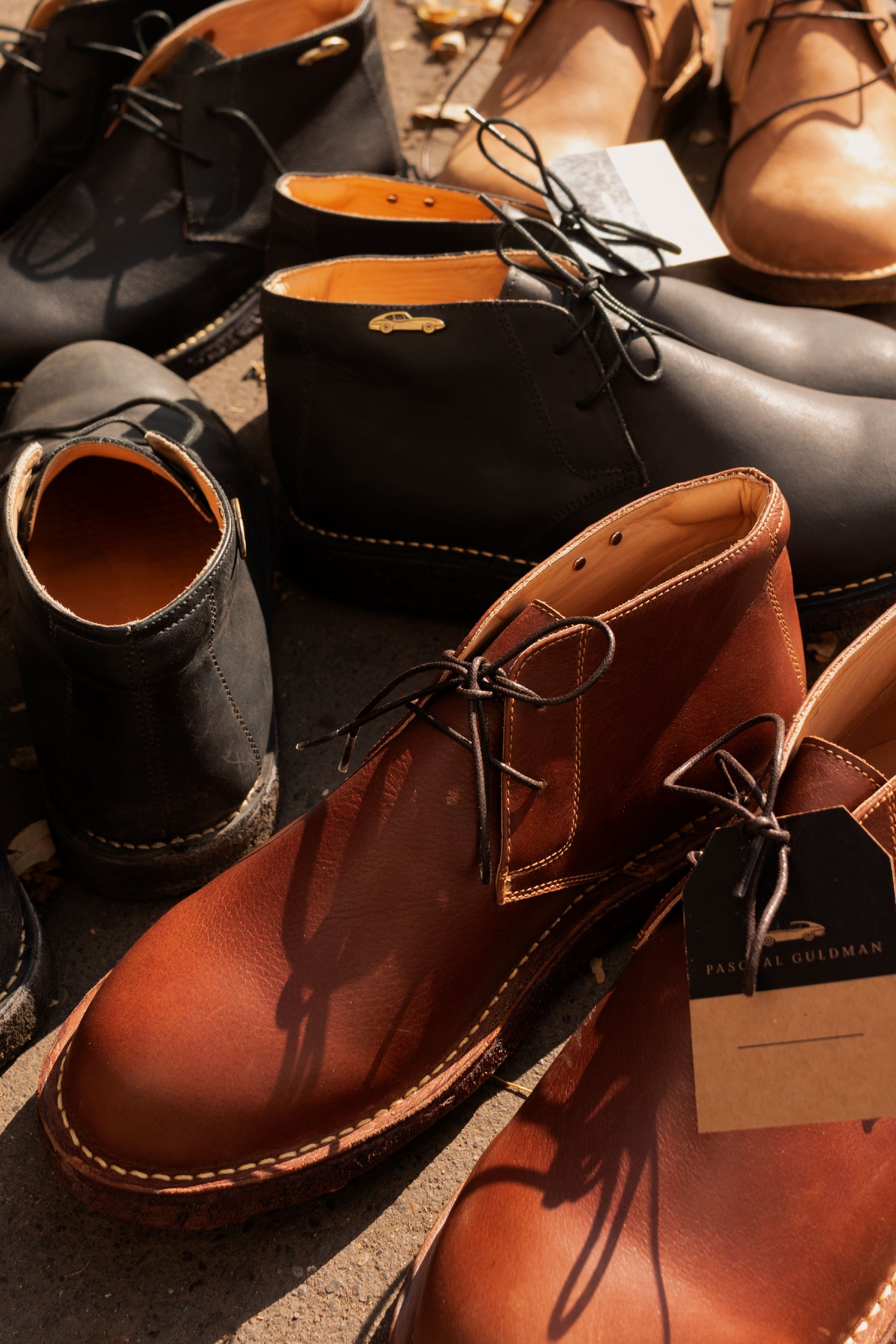 Varios pares de botas en distintos cueros dispuestos juntos.
