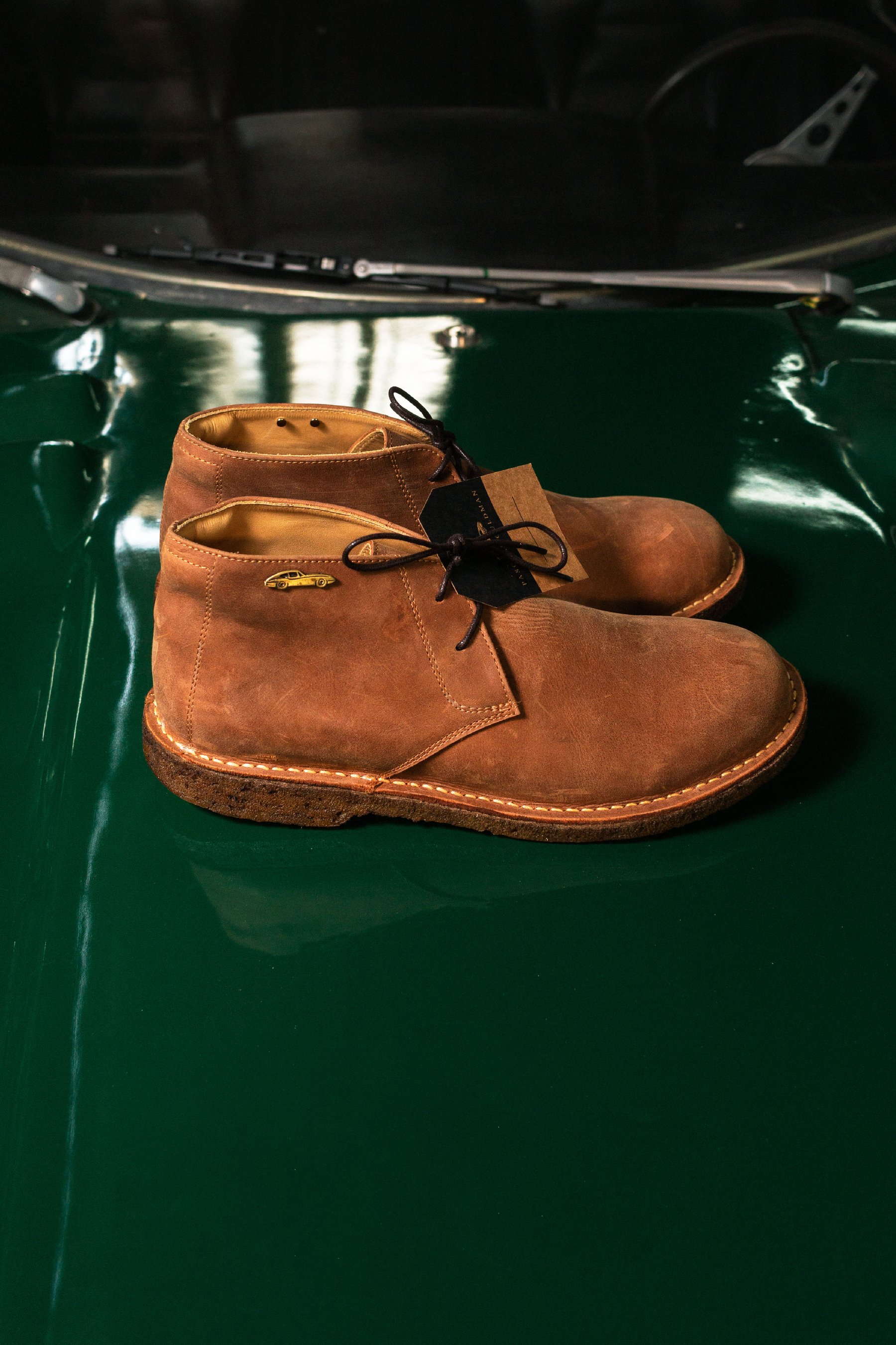 Par de botas de gamuza sobre carrocería verde.