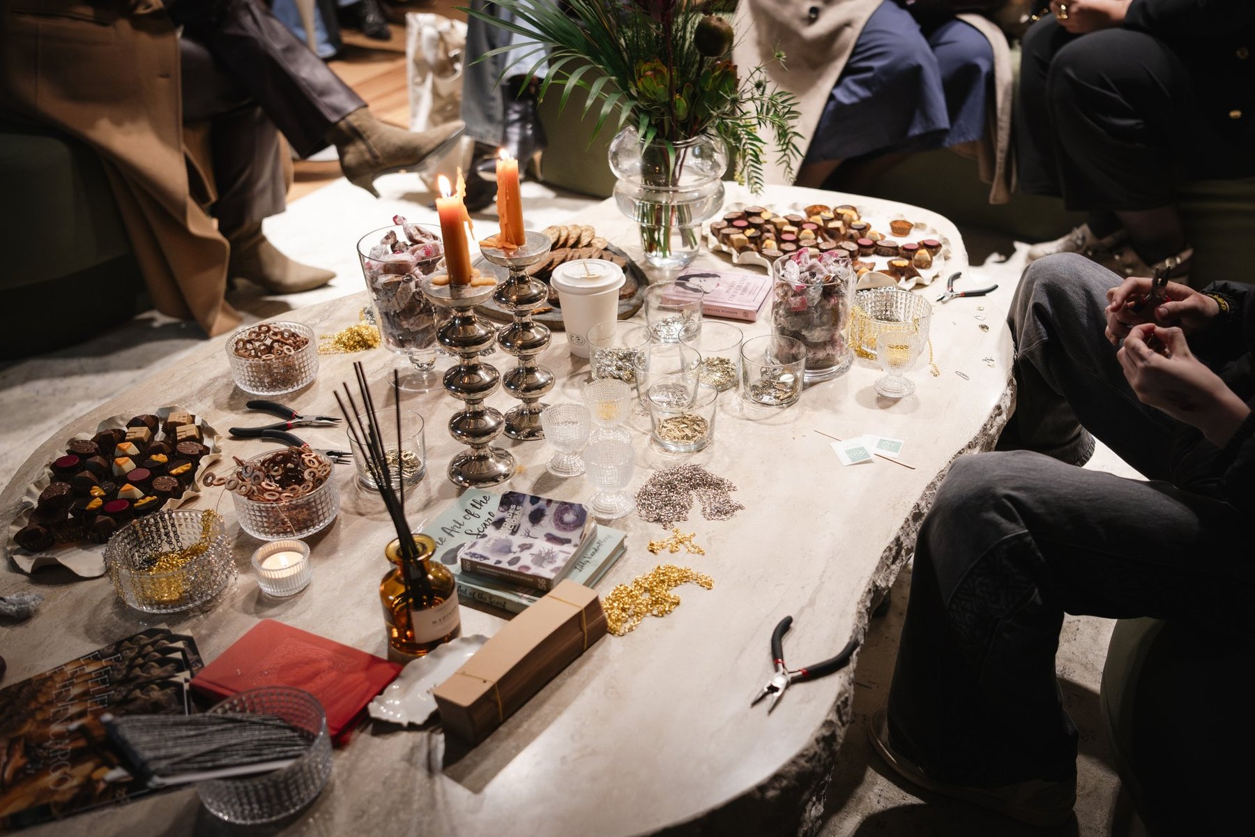 Vista cenital de la mesa larga con comida, velas y objetos.